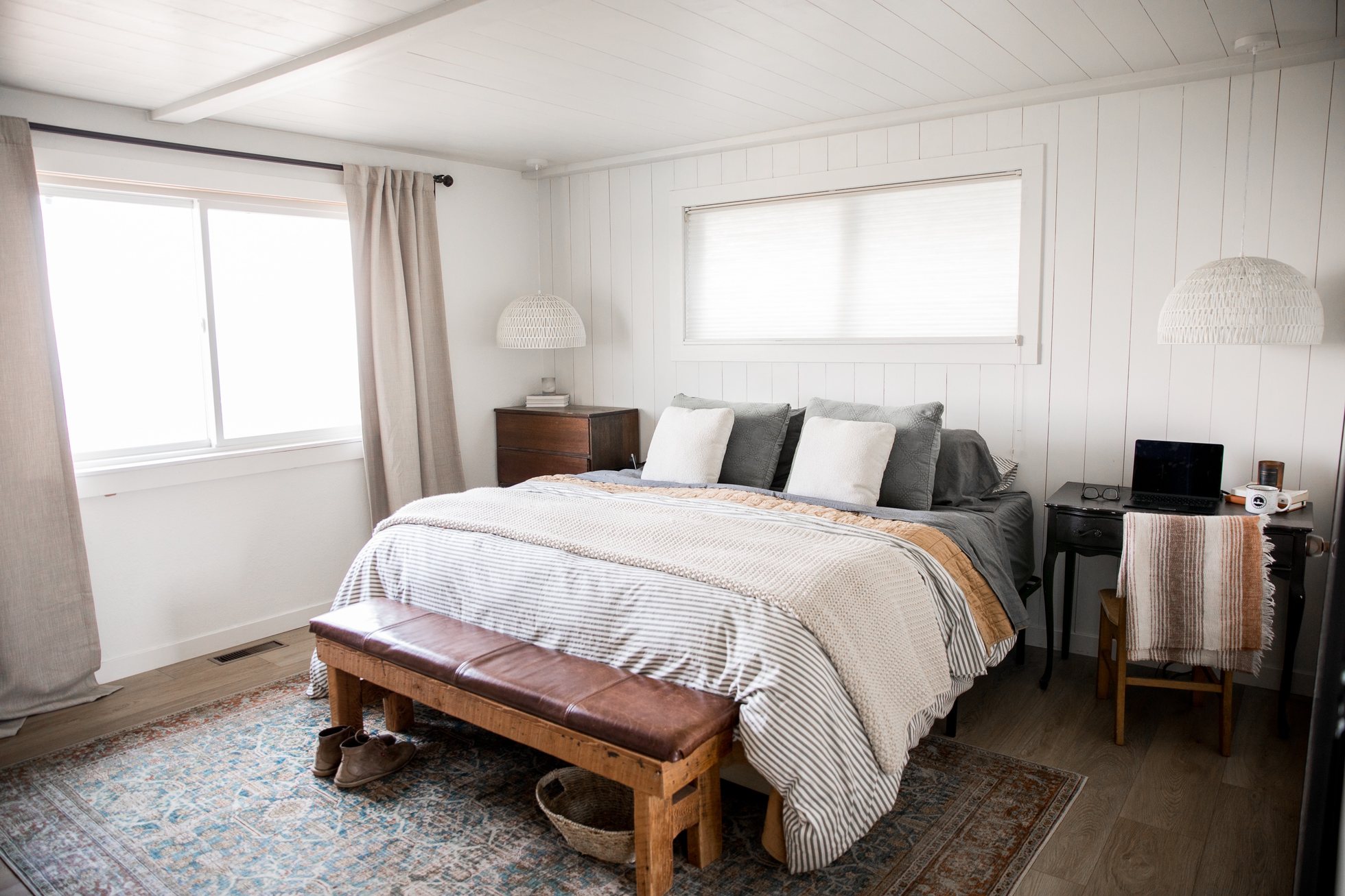 Bright bedroom with wood platform bed and neutral bedding
