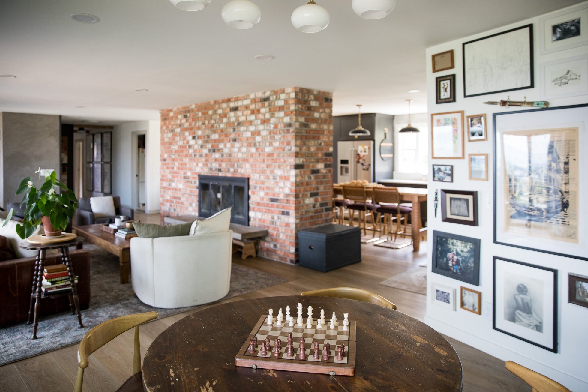 Living room with exposed brick fireplace and large windows