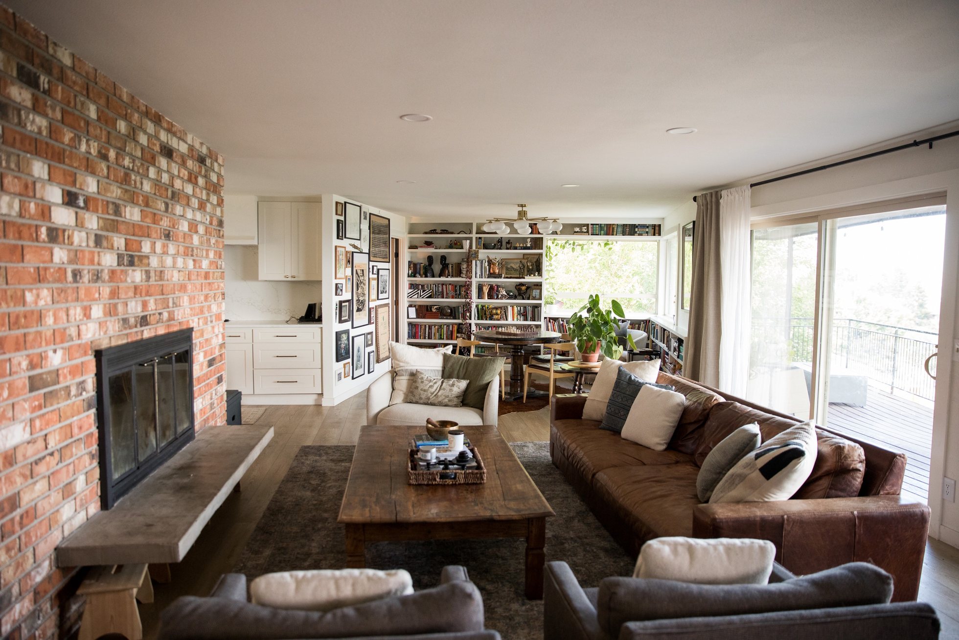 Bright, spacious living room with layered textures and a brick fireplace